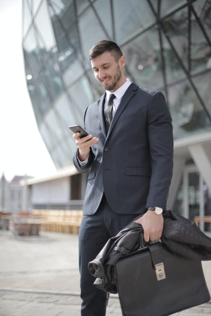 Man in black suit holding jacket, waiting for K1 Taxi